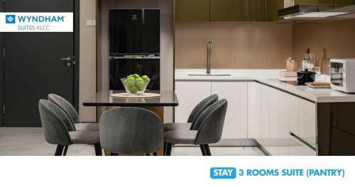 a kitchen with a table with chairs and a counter top at Wyndham Suites KLCC in Kuala Lumpur