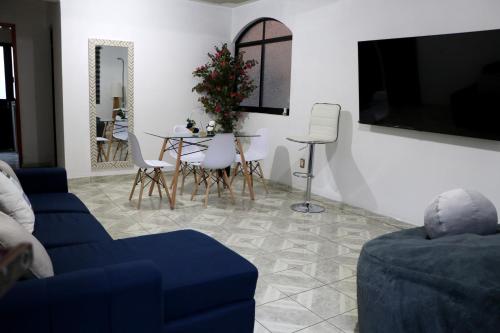 a living room with a blue couch and a table at Departamento Bugambilias in Oaxaca City
