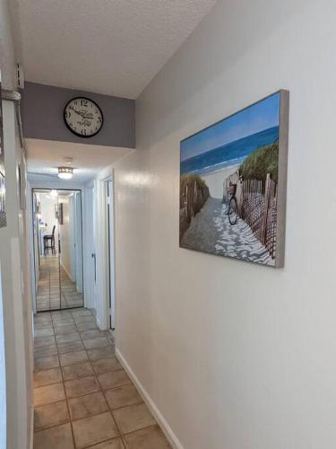 a hallway with a clock and a painting on the wall at Oceanfront 2Br-2B in Satellite Beach - Ocean Views in Satellite Beach