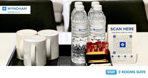 a table with two bottles of water and some snacks at Wyndham Suites KLCC in Kuala Lumpur