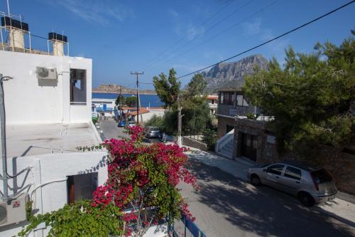 a balcony with pink flowers on a white building at Nefeli Hotel in Myrties