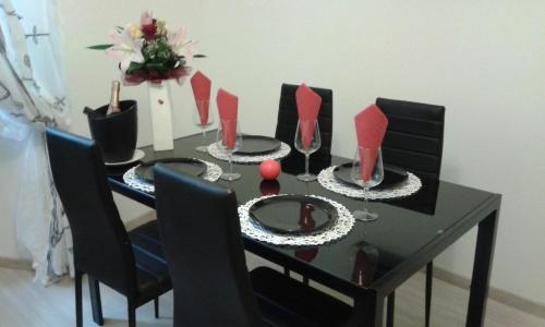 a black dining room table with wine glasses and flowers at Apartments Paris in Umag