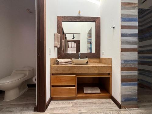 un baño con lavabo y espejo en MONTEVERDI De LUXURY, en Villa de Leyva