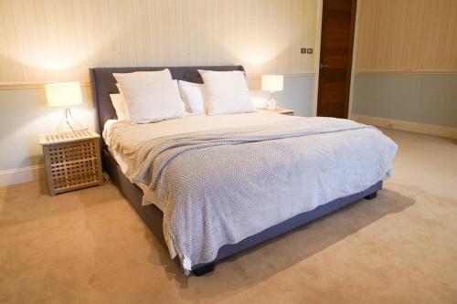 a bedroom with a large bed with two lamps at Redbank Estate - Luxury in Scone in Scone