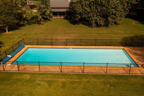 an empty swimming pool in a yard with a grass field at Redbank Estate - Luxury in Scone in Scone