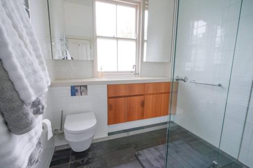 a bathroom with a toilet and a glass shower at Redbank Estate - Luxury in Scone in Scone