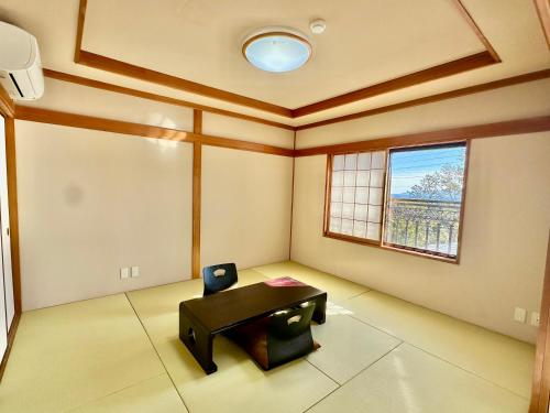 a room with a table and a chair in it at 伊東山荘-Toki- in Ito