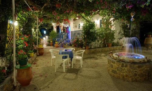 a patio with chairs and a fountain in a garden at Nefeli Hotel in Myrties