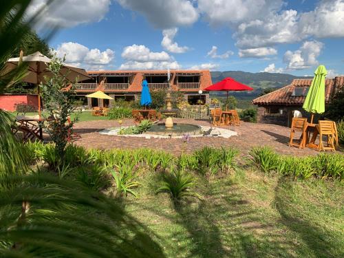 a resort with a patio with tables and umbrellas at Cabañas la odisea in Subachoque