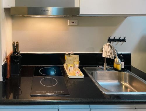 a kitchen counter top with a sink and a sink at 10mins to MOA Japan Aesthetic with Balcony Karaoke Kitchen 3mins to PICC in Manila