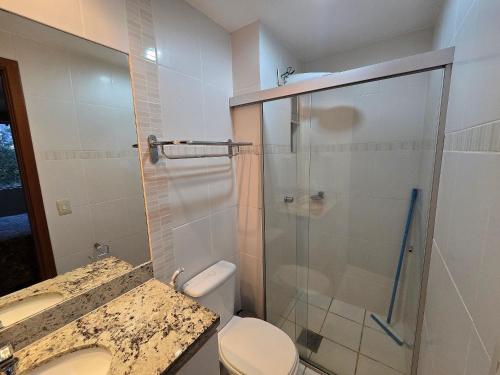 a bathroom with a shower and a toilet and a sink at Apartamentos em Rio Quente com maravilhosa área de lazer e excelente localização in Rio Quente