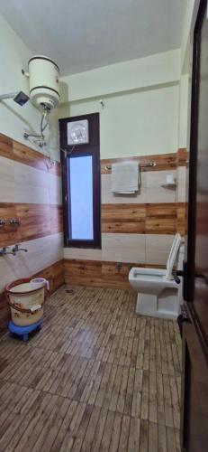 um banheiro com vaso sanitário e janela em Hotel White Villa em Shimla