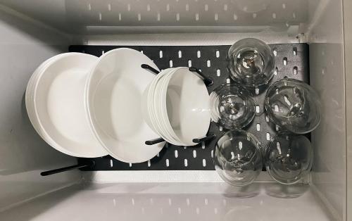three plates and glass bowls in a drawer at 10mins to MOA Japan Aesthetic with Balcony Karaoke Kitchen 3mins to PICC in Manila