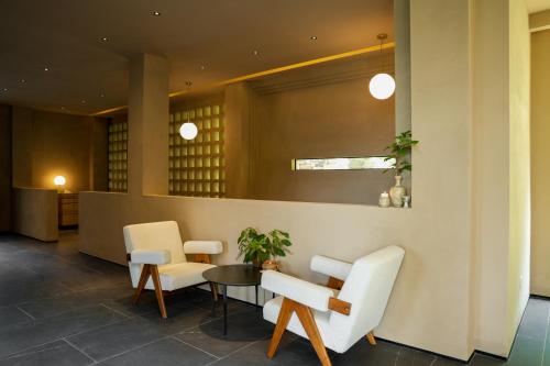 a lobby with white chairs and a table at MUUA Hotel in Wushan