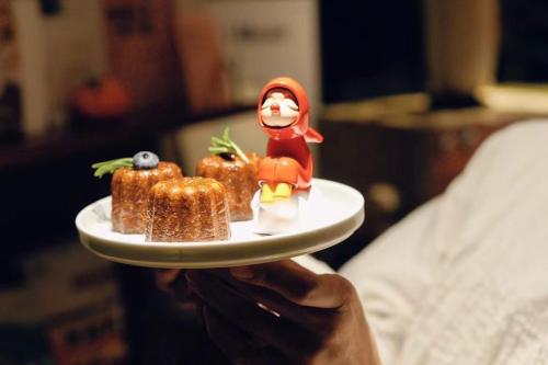 a person holding a plate with a small figurine on it at MUUA Hotel in Wushan