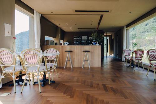 a room with chairs and a bar with a counter at MUUA Hotel in Wushan