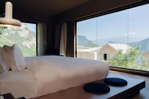 a bedroom with a large bed and a large window at MUUA Hotel in Wushan