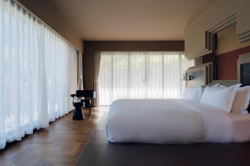 a bedroom with a white bed and a large window at MUUA Hotel in Wushan