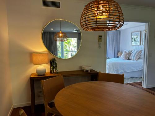 a room with a table and a bed and a mirror at Serenity style and space in tropical surrounds in Noosaville