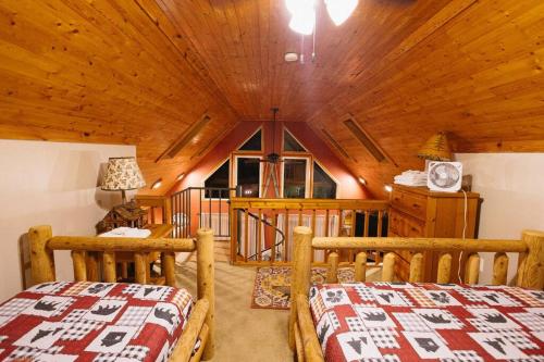 a bedroom with two beds and a wooden ceiling at Cozy Cabin By the Slopes in McHenry