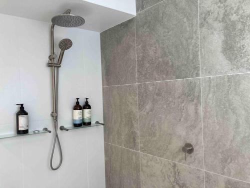 a shower with a shower head in a bathroom at Serenity style and space in tropical surrounds in Noosaville