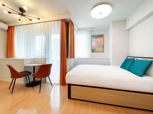 a bedroom with a bed and a table and chairs at Luce Takanawa in Tokyo