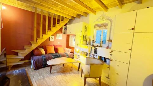 un salon avec un canapé et un escalier dans l'établissement Small duplex house in Batignolles, à Paris