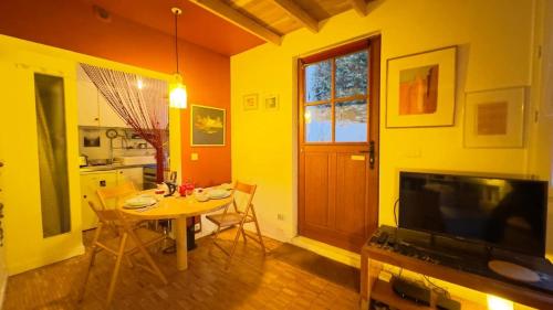 un salon avec une table et une télévision et une cuisine dans l'établissement Small duplex house in Batignolles, à Paris
