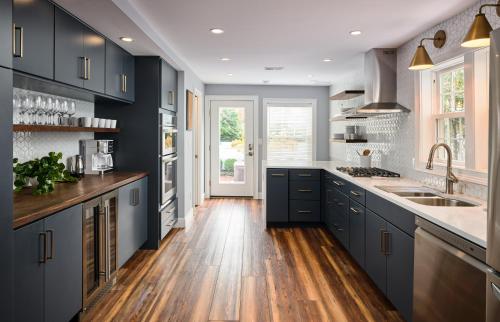 a kitchen with blue cabinets and wooden floors at The Lambertville Haven in Lambertville