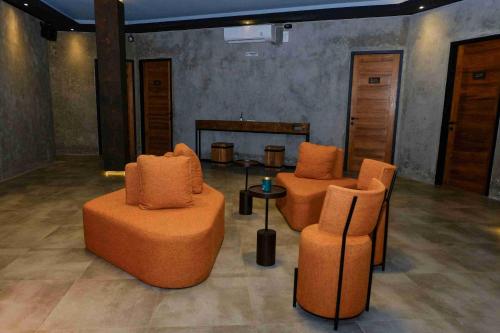 two orange chairs and a table in a room at Lyn Urban by Atmosfera in Jepara