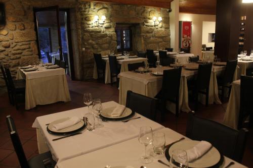 a dining room with white tables and black chairs at Quinta de Santo Estêvão Hotel Rural in Aguiar da Beira
