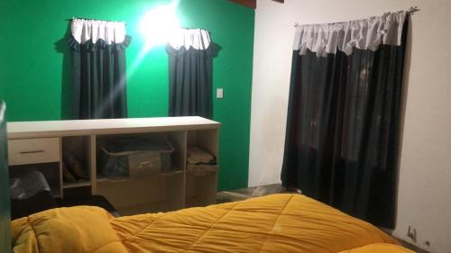 a bedroom with black curtains and a green wall at Viento Potro Casa de Campo in San Miguel del Monte