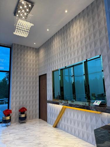 a lobby with a wall of windows and flowers at S3 Ayutthaya Hotel in Phra Nakhon Si Ayutthaya