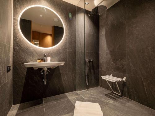 a bathroom with a sink and a mirror at Swissôtel Damian Jasna in Demanovska Dolina