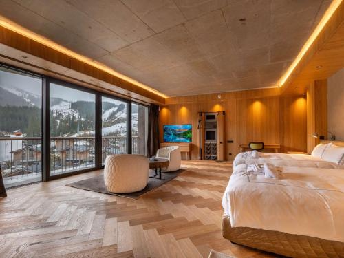 a bedroom with a large bed and a television at Swissôtel Damian Jasna in Demanovska Dolina