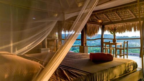 a bedroom with a bed and a window with a view at Casa Paraiso Mazunte in Mazunte