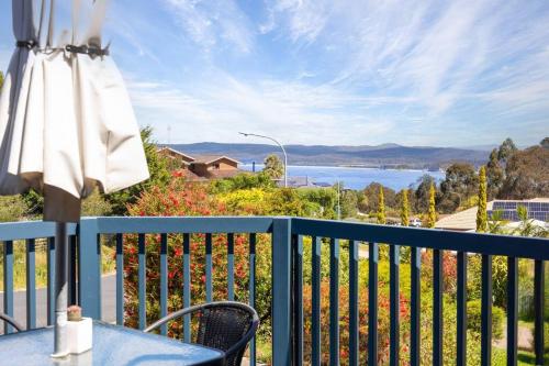 a balcony with a table and an umbrella and a view at Sapphire Belle - Views in Eden