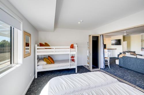 WaimaramaにあるAroha At 2252 - Waimarama Holiday Homeの二段ベッド2台と窓のある寝室