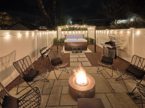 a patio with a fire pit and chairs and a tub at The Lambertville Haven in Lambertville