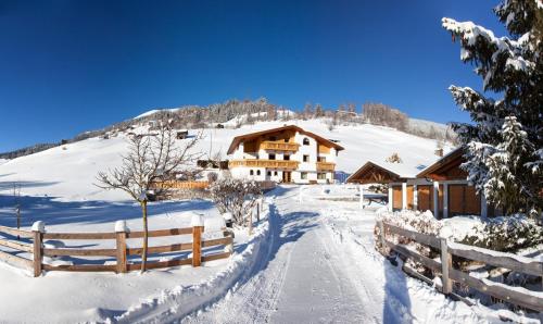 a log cabin in the snow with a fence at Ferienwohnungen Lechthaler in Wenns