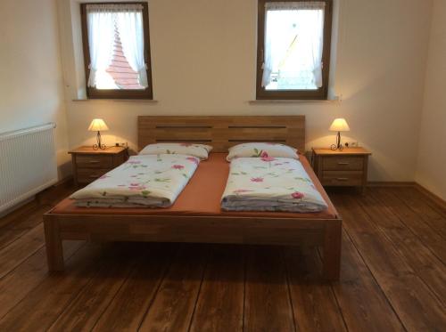 a bedroom with two beds and two windows at Atelier Reinhart in Rauhenebrach