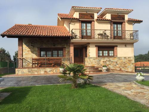 a large house with a balcony on top of it at Apartamentos rurales la Aguilera in Oviñana