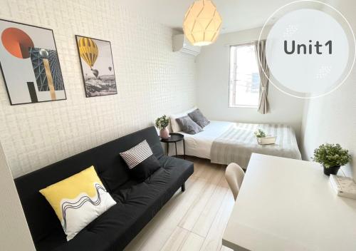 a living room with a couch and a bed at COMMA HOUSE Nishi-Ikebukuro 3F in Tokyo