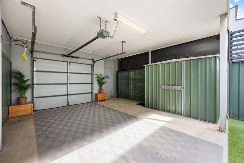 a garage with green and white garage doors at Mawson Lakes Retreat - 3BR, Wifi, Parking in Mawson Lakes