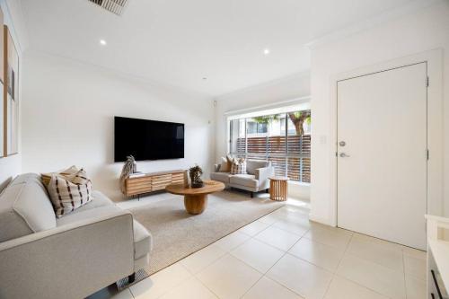 a living room with a couch and a tv at Mawson Lakes Retreat - 3BR, Wifi, Parking in Mawson Lakes