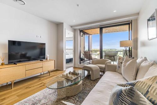 a living room with a couch and a tv at Urban Retreat 2 Bd Apt WiFi AC Parking in Auckland