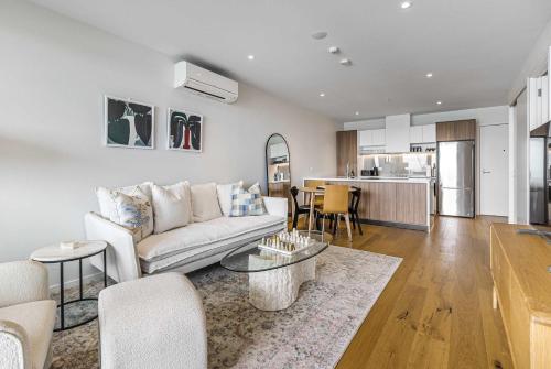 a living room with a couch and a table at Urban Retreat 2 Bd Apt WiFi AC Parking in Auckland