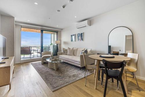 a living room with a table and a couch and a dining room at Urban Retreat 2 Bd Apt WiFi AC Parking in Auckland