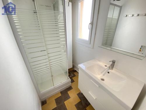 une salle de bain blanche avec un lavabo et un miroir dans l'établissement Appartement proche plage, centre-ville, équipé pour 5 personnes - FR-1-781-57, à Valras-Plage