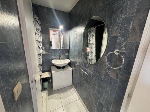 une salle de bain avec un lavabo et un miroir dans l'établissement T2 au Cap d'Agde avec piscine, parking proche plages - FR-1-749-77, au Cap d'Agde